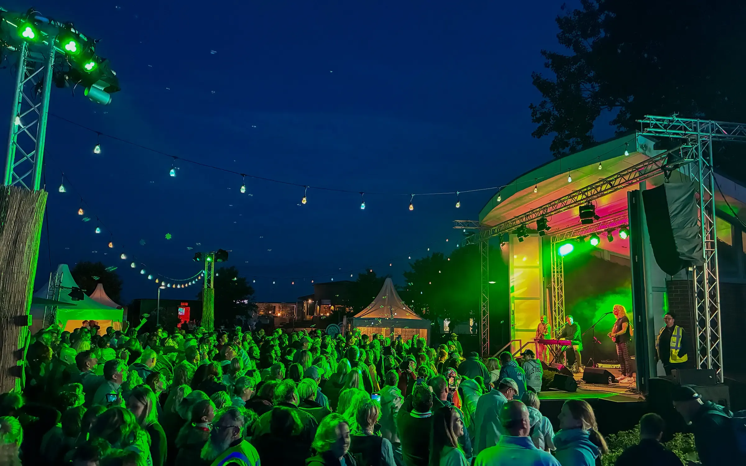 Die Hauptbühne auf dem Kurplatz beim Juistival, davor das Publikum im Abendlicht